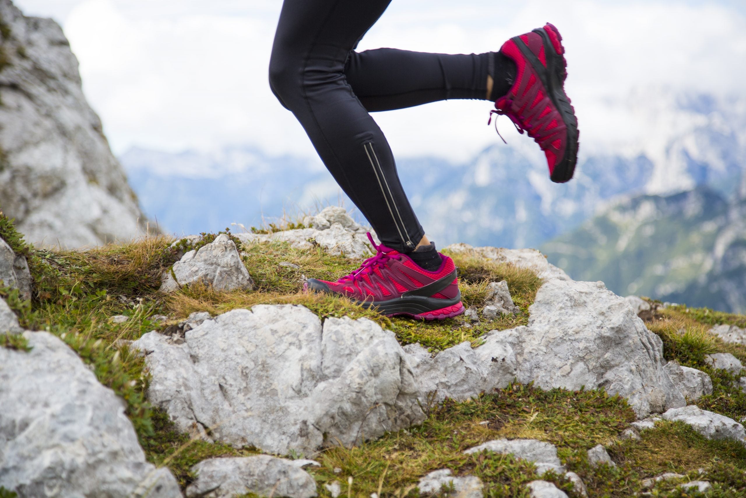 Woman running up the mountain - feet only. Trail running race.