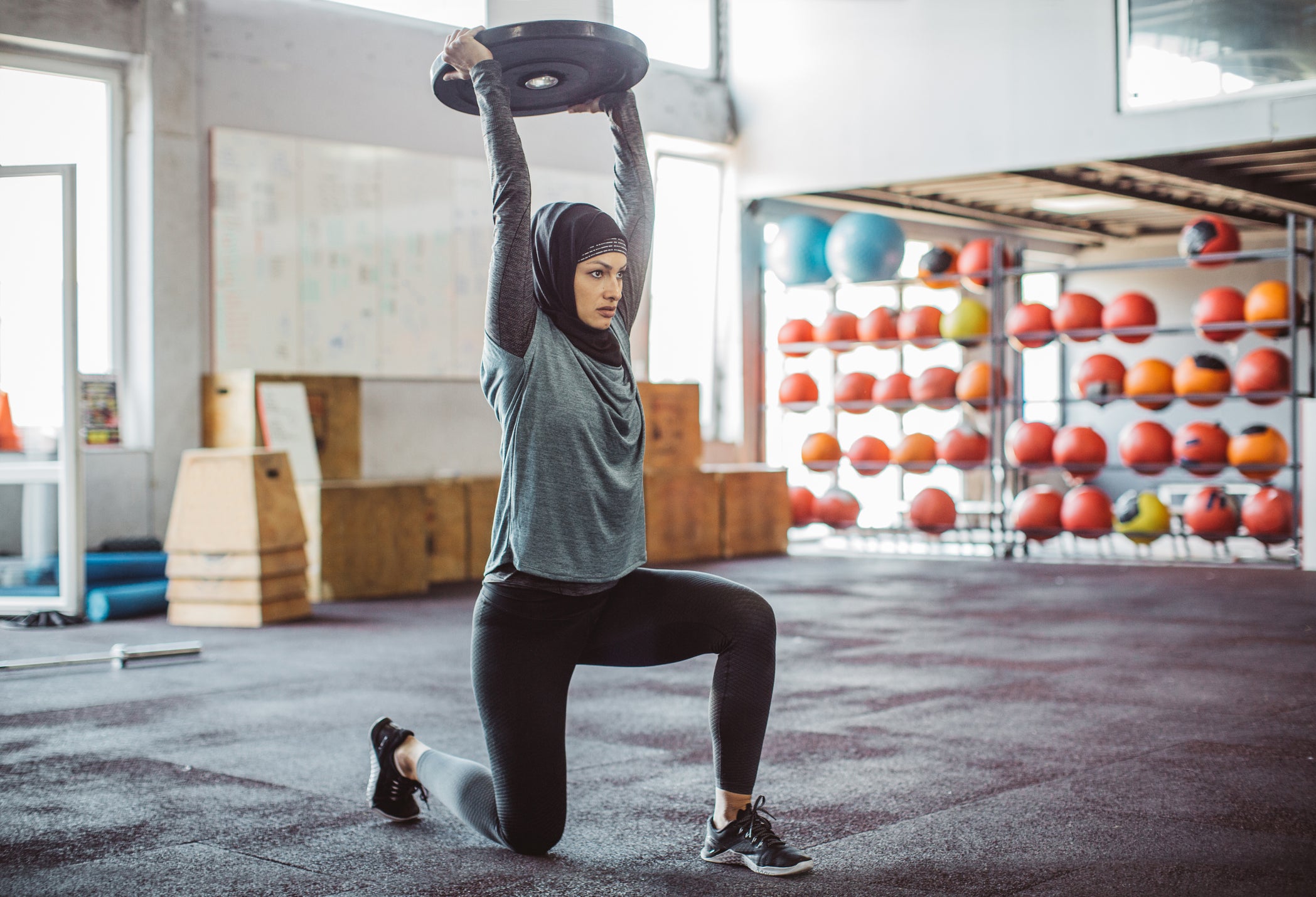 Young woman on cross training exercising. Wearing sports clothing and hijab.
