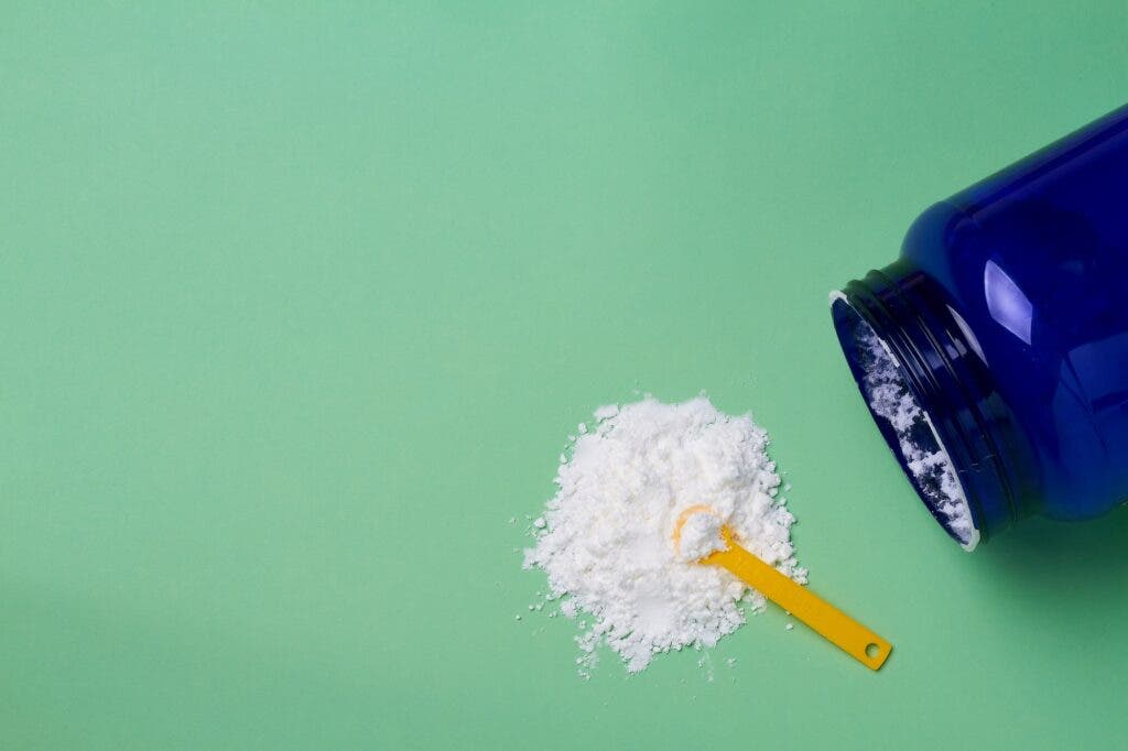 white powder supplement poured out on a green table