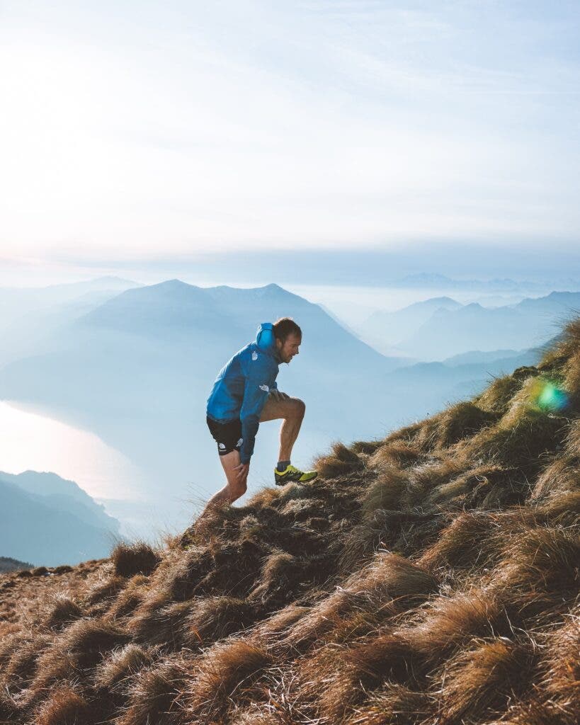 a man powerhikes up a steep incline