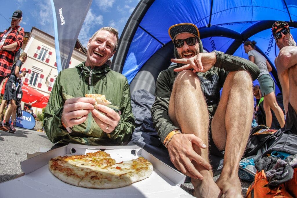 Two runners enjoy pizza at the TransAlpine Run