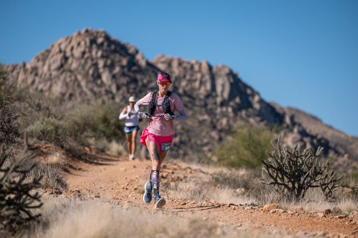 Two runners following single track through the desert.