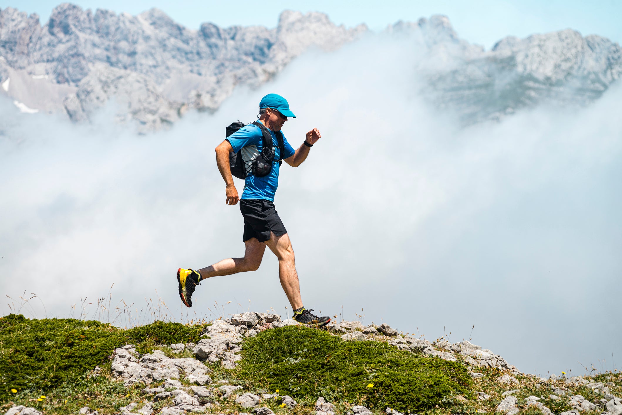 Spain, Castille and Leon, Santa Marina de Valdeon, Close view of a trail runner running in the meadows close to Collado Jermoso, Runner, Workout, Mountains, Trail Run