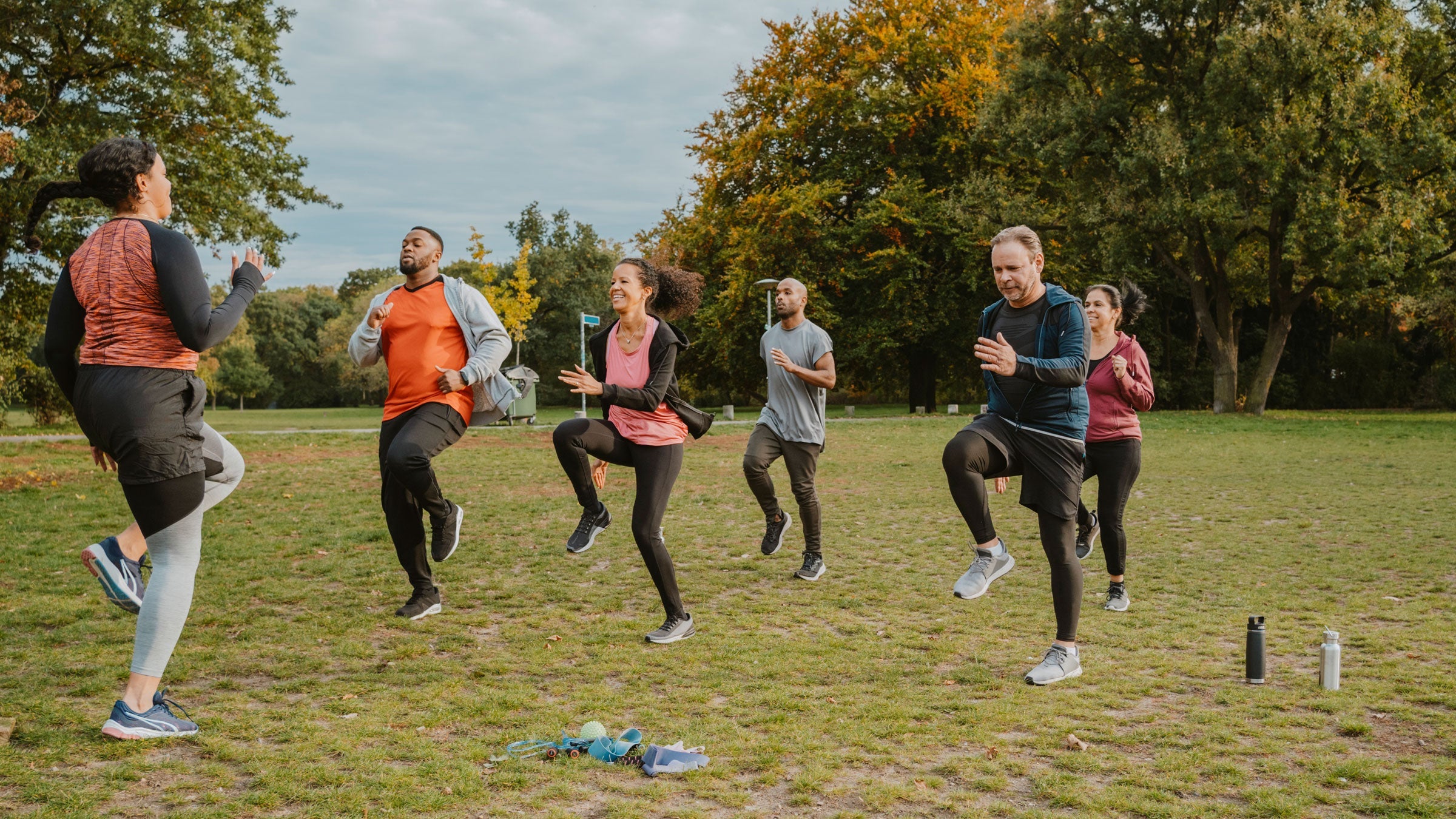 Group of active people exercise outside in a park