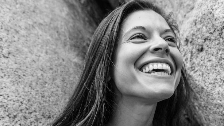 A black and white photo of a woman smiling