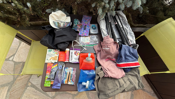overview shot looking down on a table outside packed with trail running gear next to two chartreuse-colored chairs