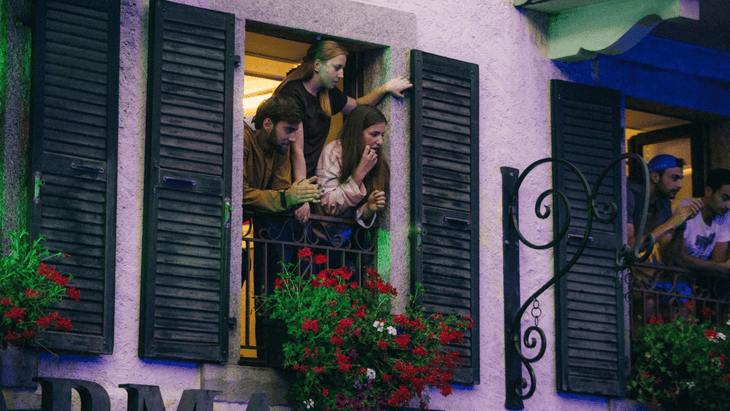 Photo of onlookers craning out of a shuttered window above the start line of the race.