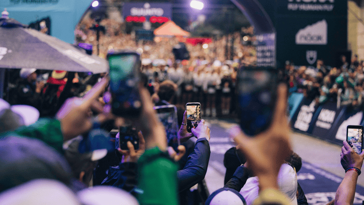 Photo of crowds holding up phones to take photos and videos of the UTMB start line.
