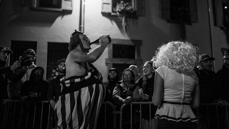 A crowdpleaser getting a drink from a bottle of wine during the night at UTMB race.