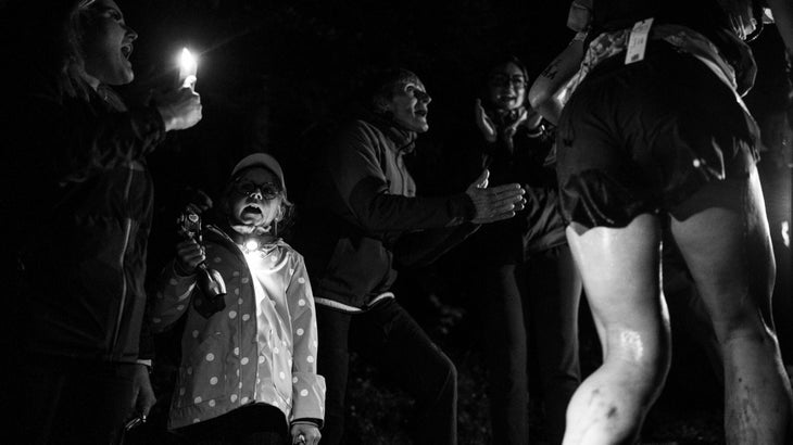 People cheering on runners during the night at the UTMB race.